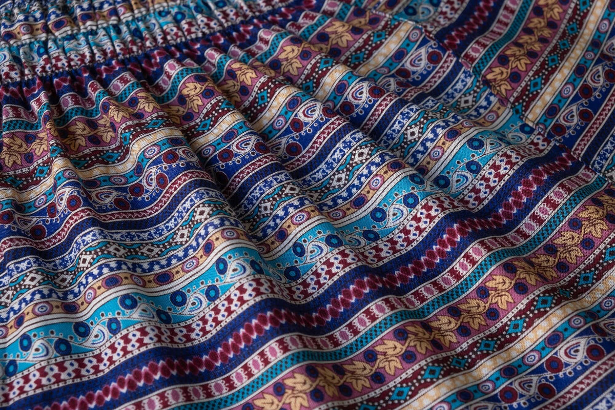 Close-up of flowing multicolor fabric pattern with dots, paisley, and stripes.