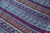 Close-up of multicolor stripe pattern on blue rayon pants fabric.